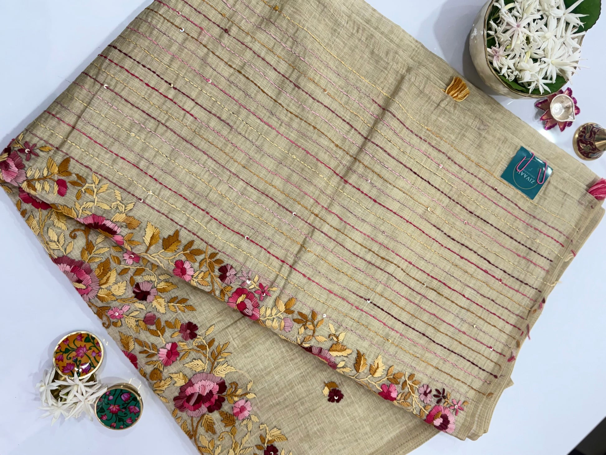Beige fabric with floral embroidery on a white background