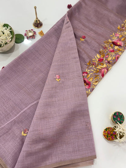 Purple fabric with gold embroidery on a white surface