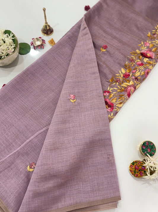 Purple fabric with gold embroidery on a white surface